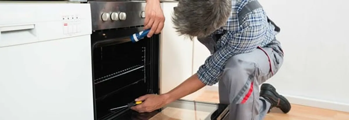 Oven repair technician inspecting and servicing an electric oven in Las Vegas, NV